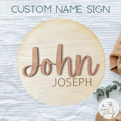 A round wooden sign that says John Joseph in a laser cut and laser engraved design. 