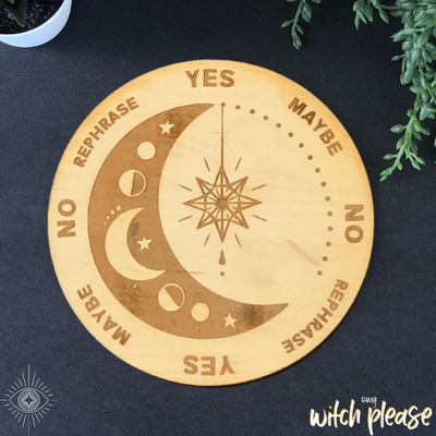 A wooden pendulum board with a crescent moon and dangle star