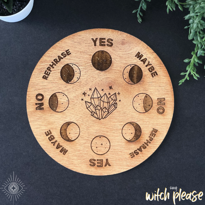 A pendulum board with a moon phase and crystal design