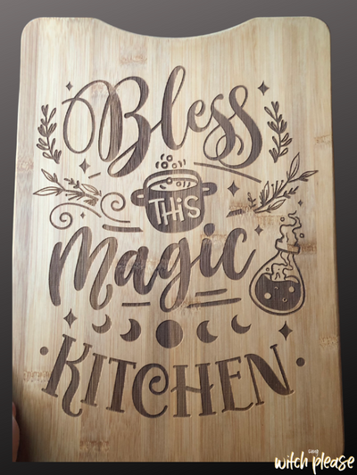 Cutting Board engraved with the words Bless this Magic Kitchen with witchy illustrations like a cauldran, potion and moon phases.