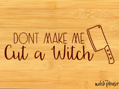 A mockup of a bamboo cutting board that has a butcher knife and the words Don't Make Me Cut a Witch
